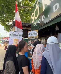 Pengunjung tampak antusias mengantre untuk membeli minuman segar di stand Sukasa selama acara Sirawu Sulo, dengan suasana yang ramai dan penuh kegembiraan.